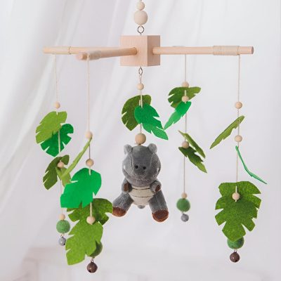 Handmade baby mobile with felt leaves, wooden beads, and a plush hippo toy for nursery decor and sensory development. Perfect for infants, adding a soothing and playful touch to the crib or cradle.