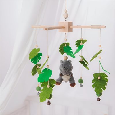 Wooden baby mobile with plush hippopotamus and felt green leaves, nursery decor for infants.