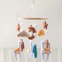 Soft baby mobile with plush clouds, stars, moons, and unicorns for nursery decoration and sensory development, featuring soothing colors and gentle designs.