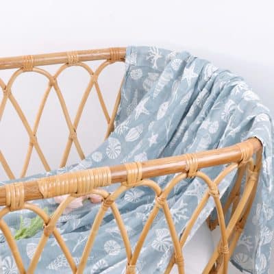 Natural wicker baby bassinet with ocean-themed fabric, ideal for baby nursery decor and safe sleep environments at Monalisa Medical.