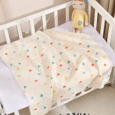 Colorful baby blanket with heart pattern on white crib, adorable plush doll, perfect for kids' bedroom decor, Monalisa Medical store.