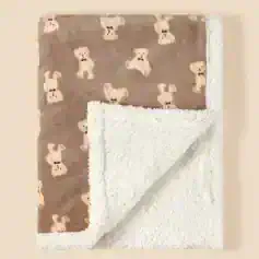 Soft plush baby blanket featuring a cuddly teddy bear pattern on one side and a fluffy white sherpa interior for warmth and comfort. Perfect for nursery decor and baby gift sets.