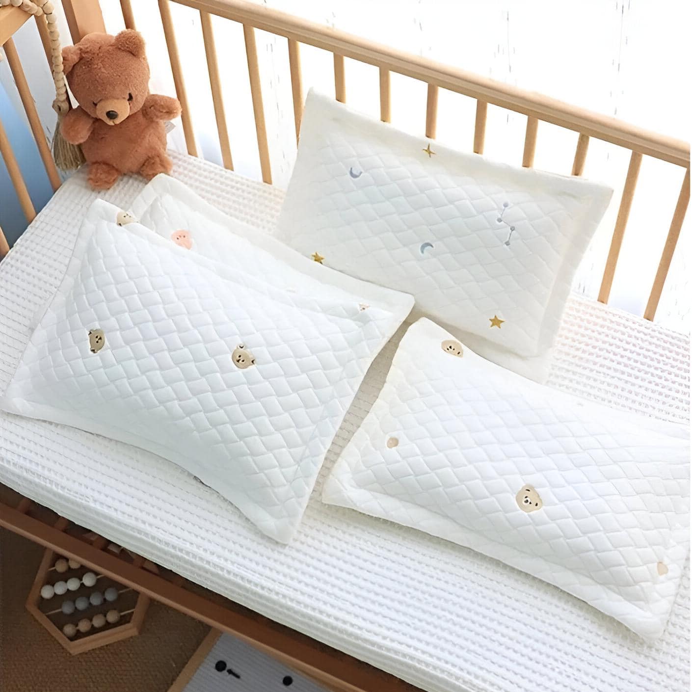 Soft white baby pillows with playful bear and star embroidered patterns, ideal for nursery bedding and sleep comfort. Perfect for infants and toddlers.