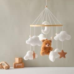 Soft plush teddy bear with cloud and star nursery mobile for infants and babies soothing decor.