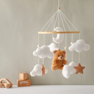 Soft plush teddy bear with cloud and star nursery mobile for infants and babies soothing decor.