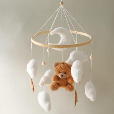 Soft baby mobile with plush teddy bear, cotton clouds, and crescent moon, designed for nursery decor, ideal for sleep and relaxation, featuring a minimalist natural wood frame.