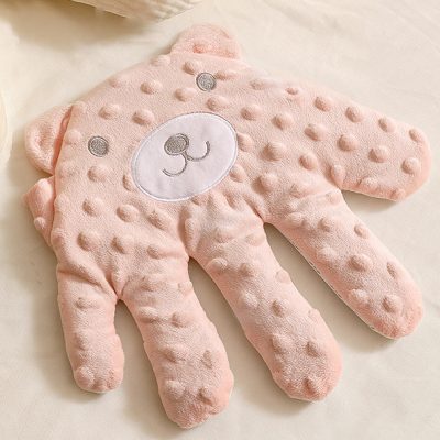 Soft pink plush teddy bear pillow with textured dotted surface, perfect for children's bedrooms or nurseries, cozy and adorable decor accessory for kids' comfort and relaxation.