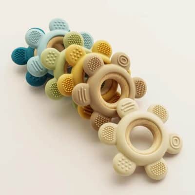 Colorful silicone baby teethers with wooden rings, soft textured for soothing gums, perfect for teething babies and infant dental care.