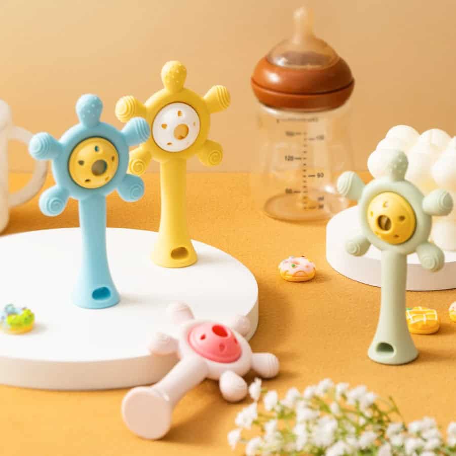 Colorful baby bottle teething toys with smiling faces in pastel shades, perfect for infant oral development and sensory play.