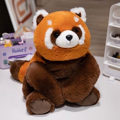 Soft plush raccoon toy, perfect for kids and collection, on a white surface with storage drawers and stationery in the background.