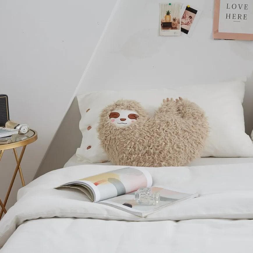 Fluffy sloth-shaped decorative pillow on a cozy bed, perfect for bedroom decor and comfort, from Monalisa Medical's stylish product collection.