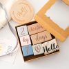 Wooden milestone blocks with "Hello World" and Christmas decorations for baby announcements or gift tags.