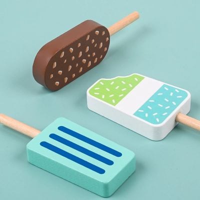 Light blue background with three colorful wooden popsicle toys featuring playful patterns, perfect for children's entertainment and educational activities.