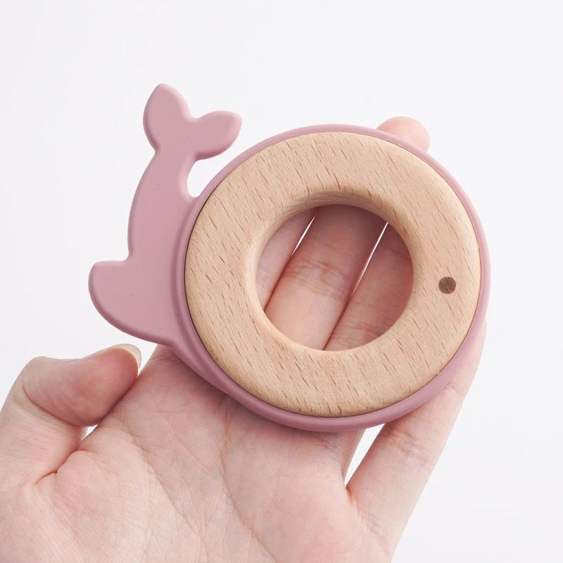 Wooden teething ring with pink whale design, baby-safe natural wood, perfect for soothing infants' gums, ideal as nursery decor, and best for early developmental stages.