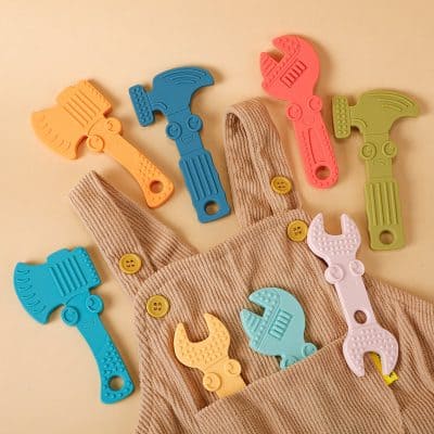 Flexible rubber hammer toy with colorful handles in a beige children's clothing pocket, playful plastic toy tools for kids, safe and fun educational toy set for early learning and motor skill development.