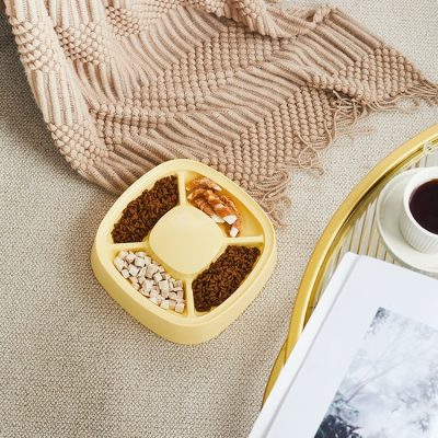 Sugar-free healthy snacks in a divided yellow container with a beige blanket and cup of coffee on a gold tray at Monalisa Store.