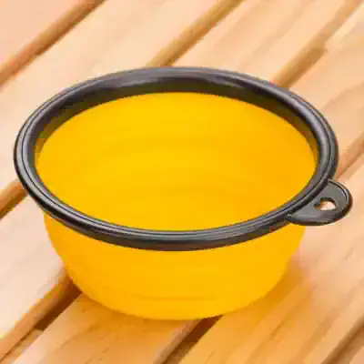 Yellow silicone mixing bowl with black rim and handle, perfect for kitchen cooking and baking utensils, durable and heat-resistant.