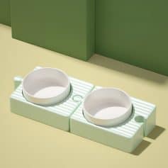 Dog feeding bowls on a green and cream-colored countertop, ideal for pet owners seeking stylish and functional pet accessories.