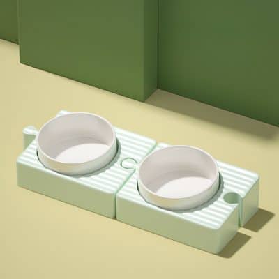 Dog feeding bowls on a green and cream-colored countertop, ideal for pet owners seeking stylish and functional pet accessories.