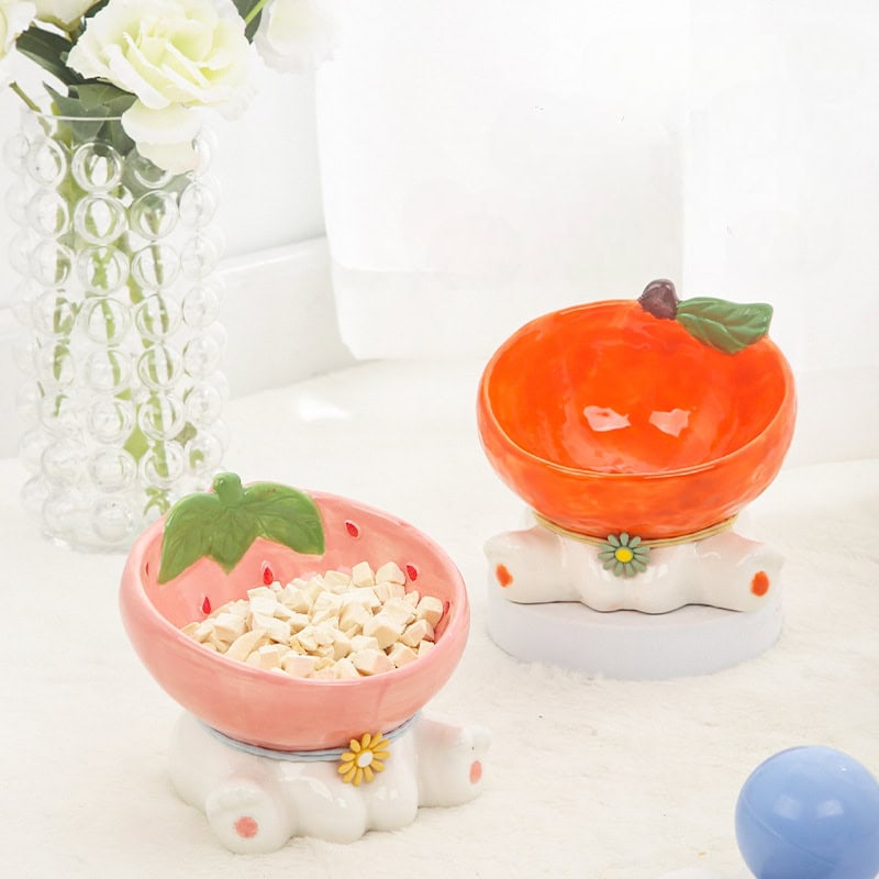Colorful ceramic fruit-themed bowls, perfect for home decor or kitchen storage, featuring strawberries and peaches with floral accents, displayed on a white surface with decorative elements.