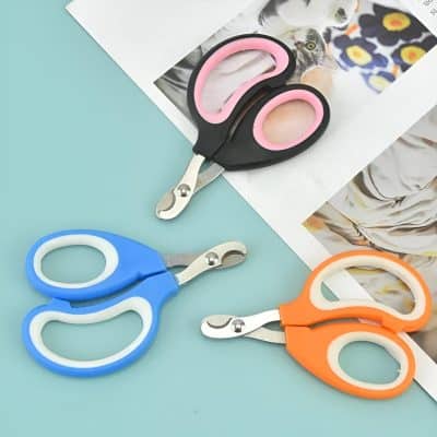Stainless steel baby safety scissors with colorful silicone handles in blue, pink, and orange, ideal for gentle trimming and grooming. Perfect for parent and child care at Monalisa Store.
