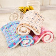 Fluffy colorful star-patterned towels, soft and cozy, perfect for bath or spa, displayed in a bright, inviting setting with decorative flowers and a miniature bicycle, emphasizing comfort and style for home use.