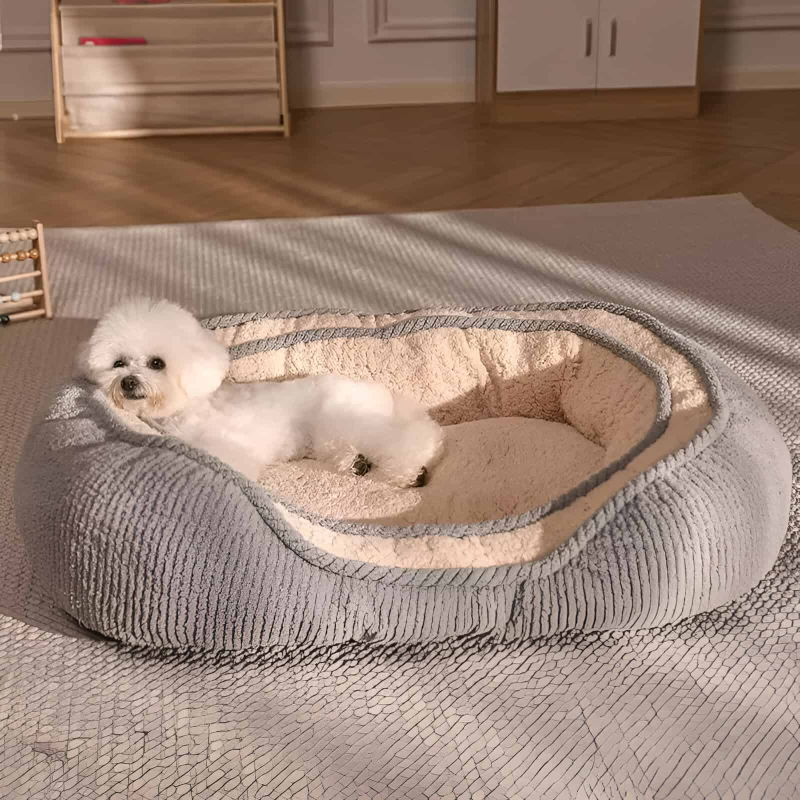 Soft plush dog bed in cozy beige and gray tones with a small white fluffy dog lounging inside, perfect for pet comfort and relaxation.