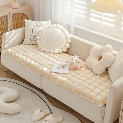 Soft white sofa with plush decorative pillows in a cozy, modern living room setting, featuring natural light, neutral tones, and stylish decor elements.