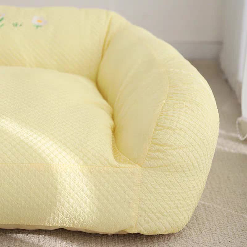 Soft yellow cushioned armchair with quilted fabric, perfect for a relaxing corner in a living room or nursery, featuring a cozy and inviting design.
