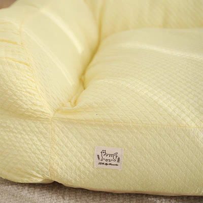 Soft yellow plush cushion with a stitched logo of a playful cat, featuring subtle diamond pattern textures, designed for comfort and aesthetic appeal in home or store decor.