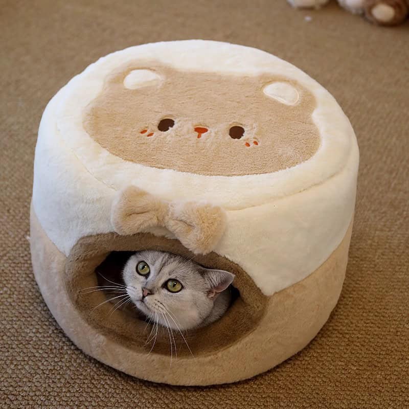 Cute gray cat inside a cozy beige and white plush cat bed with a bear face design, perfect for pet comfort and relaxation.