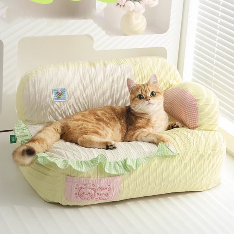 Soft plush cat bed with a cute pink heart pillow on a sunny windowsill, ideal for relaxing and napping, perfect for pet comfort and home decor.