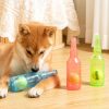 Bright Shiba Inu puppy playing with colorful toy bottles, indoor setting.