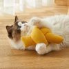 Fluffy cat playing with a yellow plush toy on wooden floor, showcasing pet comfort and playtime essentials for pet lovers.