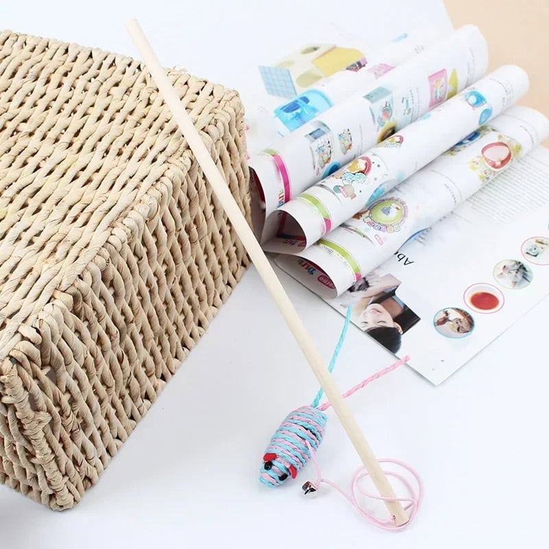 Woven basket with wooden stick, colorful rolled papers and cat toy on white surface, promoting Monalisa Store's optical and eyewear accessories.