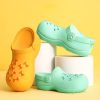 Yellow dog shoe with orange bone pattern for pets, playful and comfortable dog footwear, perfect for outdoor walks and rainy days.