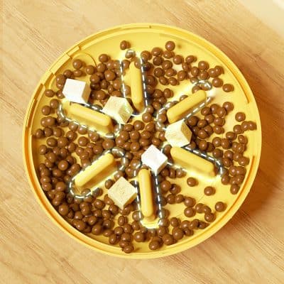 Colorful puzzle game with balls and cubes in a yellow circular tray for brain stimulation and entertainment.