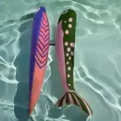 Vibrant pair of colorful sock fins resembling fish fins floating in clear pool water, perfect for aquatic activities and swim training, showcasing fun and functional pool accessories.