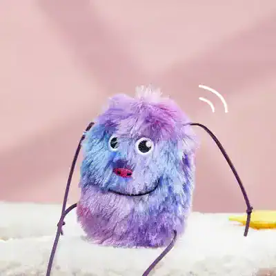 Cute fluffy purple and blue stuffed animal with a smiling face and googly eyes, designed for kids' toys or decorative purposes.