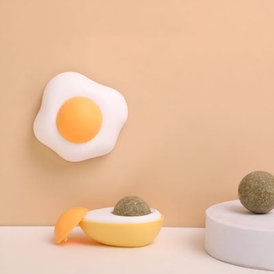 Fried egg-shaped massage device on wall with herbal ball therapy products in beige tones for relaxation and skincare.