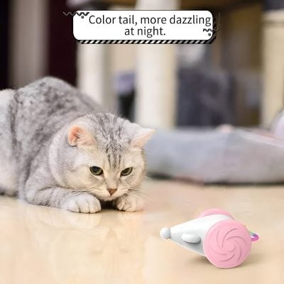 Cute grey tabby cat lying on a table with a pink and white toy mouse for pets, emphasizing playful pet accessories at Monalisa Medical Store.