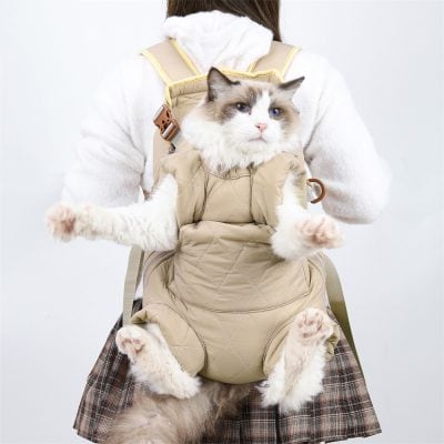 Fluffy Ragdoll cat in beige pet carrier on person’s chest, pet travel carrier for cats, comfortable cat backpack for travel, Monalisa Store pet accessories, pet carrier for cats and small animals.
