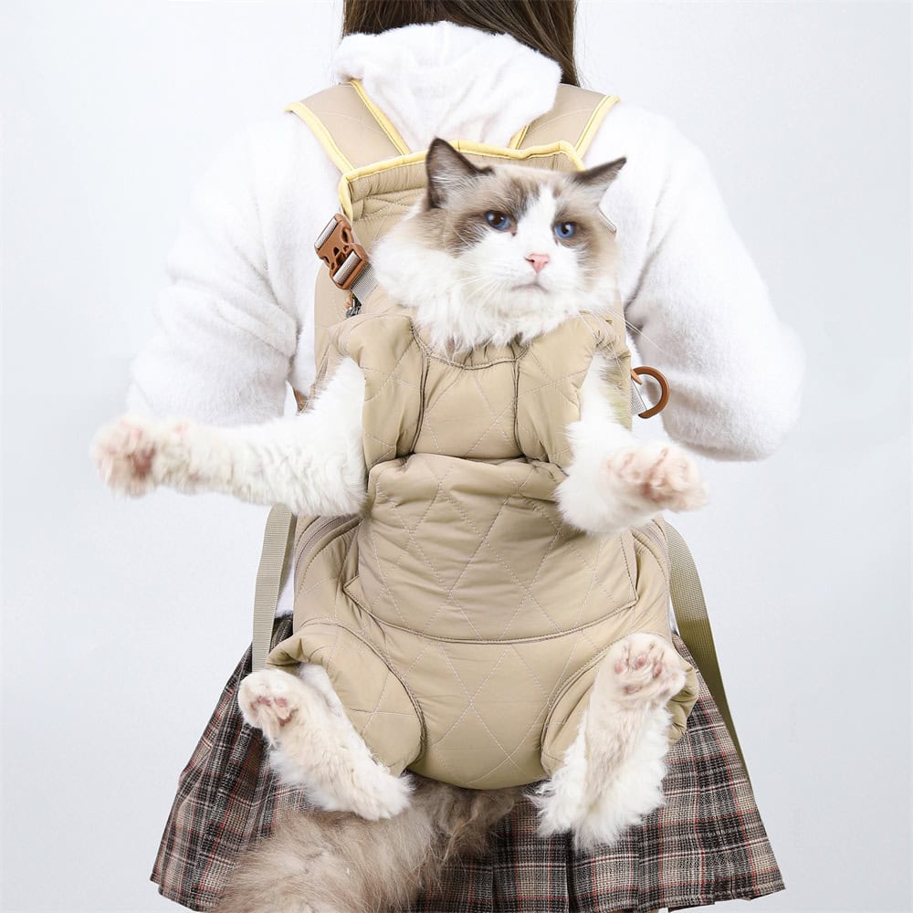 Fluffy Ragdoll cat in beige pet carrier on person’s chest, pet travel carrier for cats, comfortable cat backpack for travel, Monalisa Store pet accessories, pet carrier for cats and small animals.
