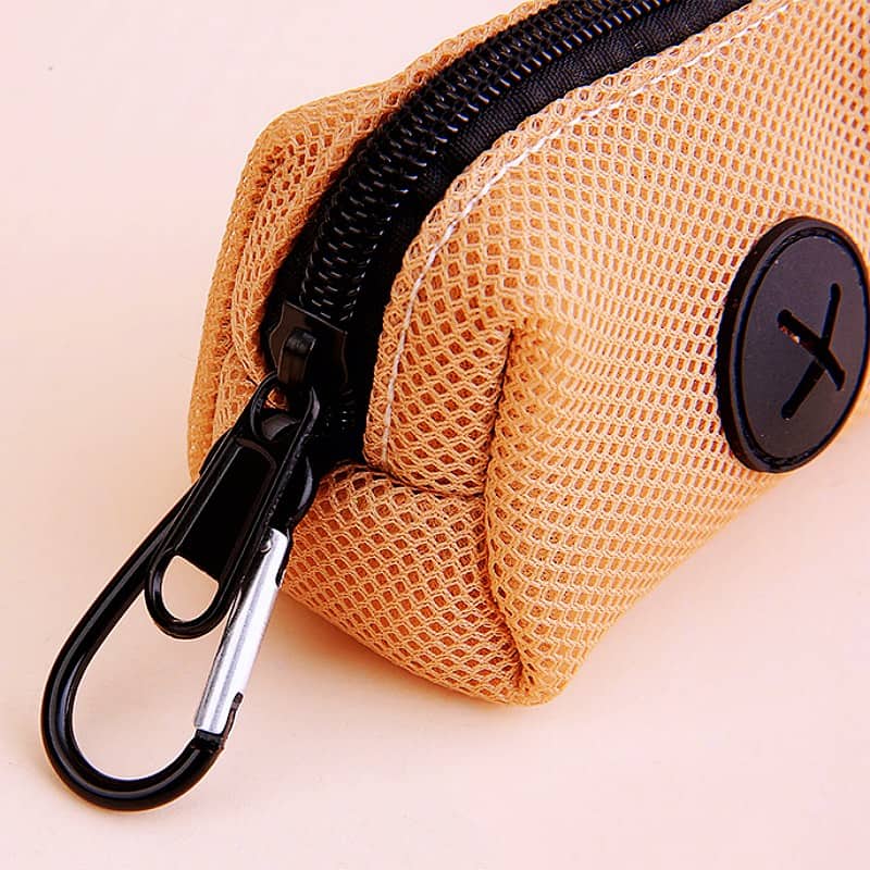 Light orange mesh pouch with black zipper and carabiner clip, ideal for storing small accessories or eyeglasses, featuring a circular logo patch.