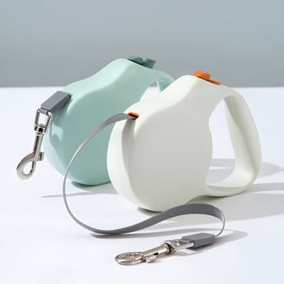 Soft pastel-colored pet retractable leashes with ergonomic handles, ideal for dog walking, showcased in a clean, modern setting. Perfect for pet owners seeking functional and stylish pet accessories.