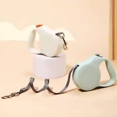 Stylish modern pet waste bag dispensers with retractable leash attachments, designed for convenient pet waste cleanup and outdoor walks, in a clean minimalist aesthetic.