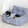Pet dog resting on a stylish striped pet sofa, perfect for comfort and modern home decor, ideal for small dogs and puppy lounging.