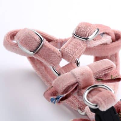 Pink pet harness with adjustable straps and metal D-rings for secure outdoor walks, made from soft, comfortable fabric, ideal for small dogs and cats.