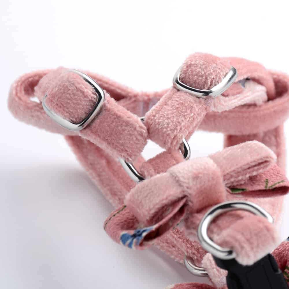 Pink pet harness with adjustable straps and metal D-rings for secure outdoor walks, made from soft, comfortable fabric, ideal for small dogs and cats.