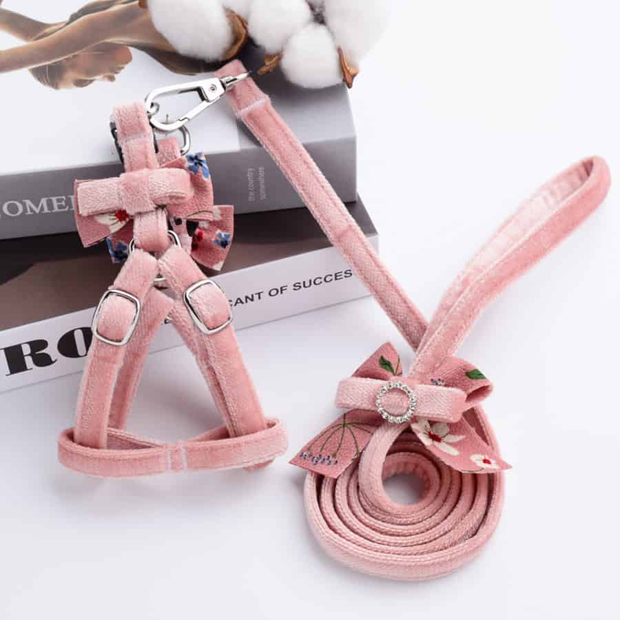 Pink pet harness and collar set with bow and decorative ring, ideal for small dogs and puppies. Comfortable, stylish, and perfect for outdoor walks.